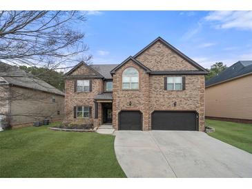 Two-story brick home with a two-car garage and well-manicured lawn at 2268 Austin Common Way, Dacula, GA 30019