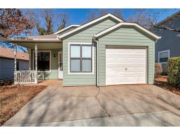 Charming home features light green siding and a one car garage at 4676 Cedar Park Trl, Stone Mountain, GA 30083