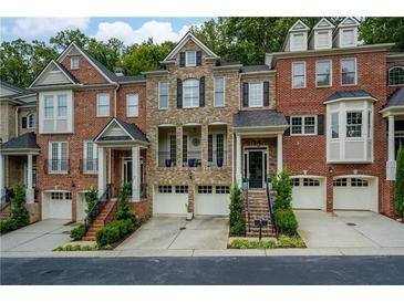 Charming townhome showcasing brick facade, private garages, and well-maintained landscaping, creating a welcoming curb appeal at 5964 Reddington Way, Sandy Springs, GA 30328