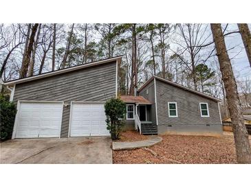 Two-story home featuring a two-car garage, gray siding, and a small, neatly landscaped front yard at 3515 Weathered Wood Dr, Ellenwood, GA 30294