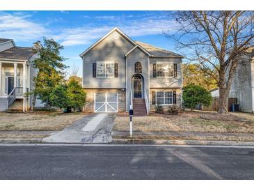 Charming two-story home with gray siding, stone accents, and a well-maintained front yard at 5806 Highgrove Dr, Atlanta, GA 30349