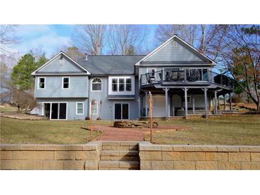 Stunning home with a deck, outdoor stone firepit and manicured lawn at 1104 Fox Ln, Woodstock, GA 30188