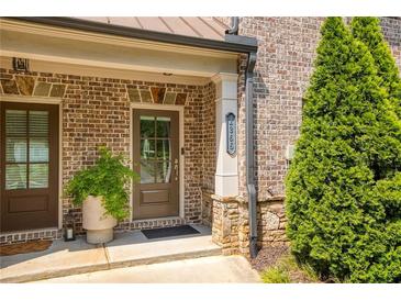 Charming brick home entrance with a well-manicured landscape and a cozy, inviting front door at 1365 Hawthorne Se Ave, Smyrna, GA 30080