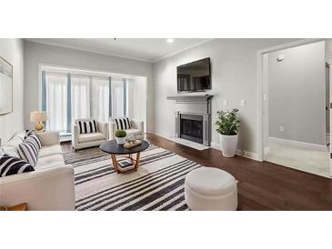 Bright living room with a fireplace, large window, plush seating, and a striped rug at 2865 Lenox Ne Rd # 410, Atlanta, GA 30324