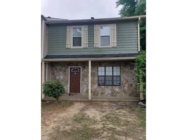 Two-story townhome with stone facade, covered porch, and decorative window shutters at 3500 Ten Oaks Ct, Powder Springs, GA 30127