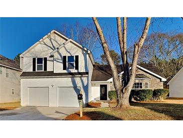 Charming two-story home boasts a manicured lawn, two-car garage, and inviting stone accents at 2822 Ward Lake Way, Ellenwood, GA 30294