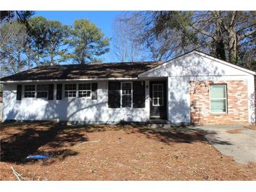 Charming single-story home with a painted white brick and dark shutters, offering timeless curb appeal at 6441 Holiday Blvd, Forest Park, GA 30297