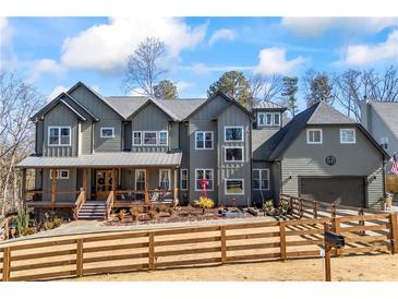 Charming two-story home featuring a covered porch, fenced yard, and attached garage at 4115 Merritt Dr, Cumming, GA 30041