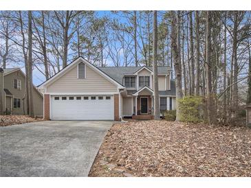 Charming two-story home with brick accents and a two-car garage nestled amongst mature trees at 3214 Country Walk Dr, Powder Springs, GA 30127