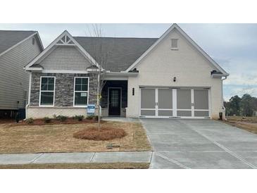 Charming single-Gathering home featuring a brick and stone facade, complemented by a well-manicured lawn at 822 Kestrel Dr, Loganville, GA 30052