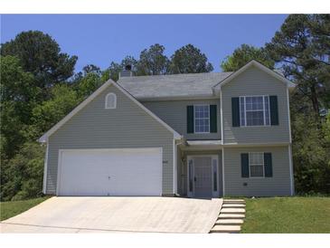 Charming two-story home with gray siding, dark shutters, attached two-car garage, and well-manicured landscaping at 5627 Isleworth Ct, Atlanta, GA 30349