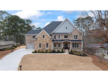 Beautiful two-story brick home featuring a manicured lawn and a spacious driveway leading to an attached garage at 3669 High Green Dr, Marietta, GA 30068