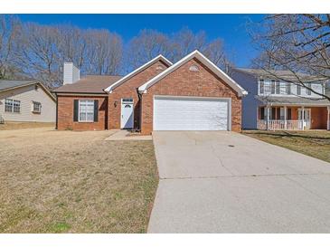 Charming single-story brick home featuring an attached two-car garage and a well-maintained front yard at 983 Oakwood Chase Cir, Stone Mountain, GA 30083