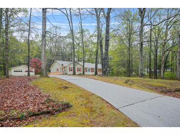 Ranch style home with red shutters is surrounded by mature trees at 125 Bridget Dr, Hampton, GA 30228