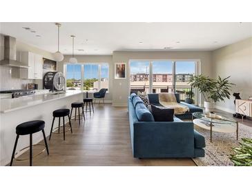 Bright, open-concept living space featuring hardwood floors, modern kitchen, and a comfortable seating area with balcony access at 22 Airline Ne St # 403, Atlanta, GA 30312