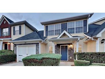 Inviting home exterior featuring stone accents, a blue front door, and an attached garage at 640 City Park Dr, Mcdonough, GA 30252