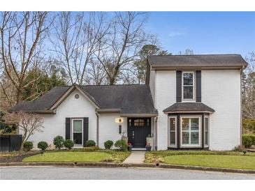 Charming two-story home with a well-manicured lawn, white brick facade, and black door at 2861 Dorby Close Ne, Brookhaven, GA 30319