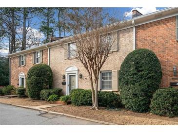 Charming brick townhome featuring manicured landscaping and a welcoming entrance at 1659 Executive Park Ne Ln, Brookhaven, GA 30329