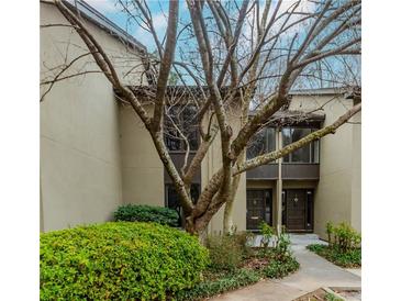 Inviting condo exterior featuring well-maintained landscaping, mature tree, and private entrances at 20 Ivy Ne Rdg, Atlanta, GA 30342
