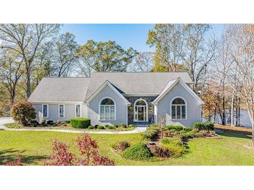 Beautiful single-story home featuring a stone facade, arched windows, and a well-maintained lawn at 205 Pine Knott Rd, Fayetteville, GA 30214
