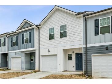 Charming townhomes featuring varied siding colors, garages, and well-maintained lawns at 5063 Lower Elm St, Atlanta, GA 30349