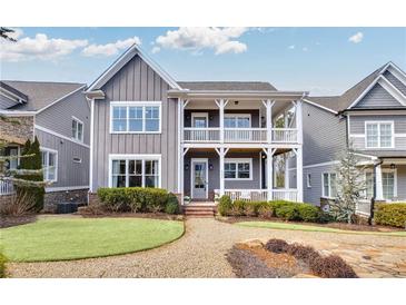 Charming two-story home with a welcoming double-decker porch and beautifully landscaped front yard at 2304 Isla Run, Woodstock, GA 30188