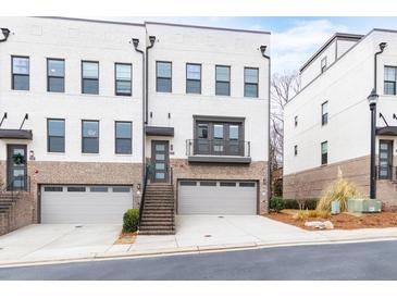 Contemporary townhome featuring white painted brick, gray garage door, and a private balcony at 4374 Benfield Se Way # 1801Lo, Smyrna, GA 30080