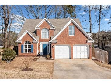 Charming two-story brick home with a well-maintained lawn and two-car garage at 565 Saint James Ct, Lawrenceville, GA 30044