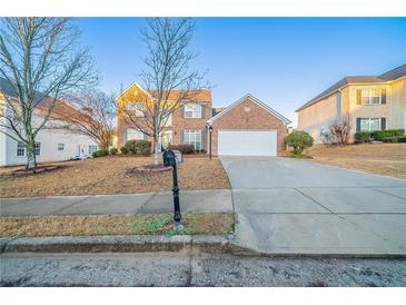 Charming two-story brick home with a well-manicured front yard and a two-car garage at 2397 Shady Maple Trl, Loganville, GA 30052