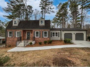 Charming brick home with a well-manicured lawn and an attached two-car garage at 6390 E Stubbs Rd, Atlanta, GA 30349