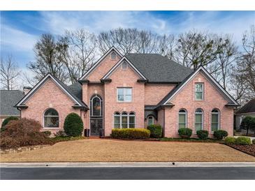 Charming brick home featuring well-maintained landscaping and a classic architectural style at 9135 Etching Overlook, Johns Creek, GA 30097