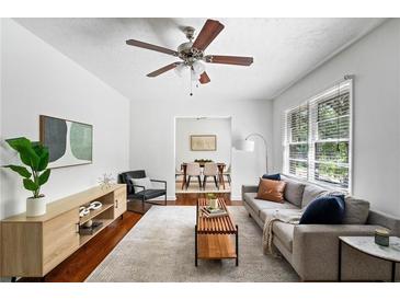 Bright living room featuring a ceiling fan, hardwood floors, neutral-colored furniture, and an open floor plan at 2107 Seavey Dr, Decatur, GA 30032