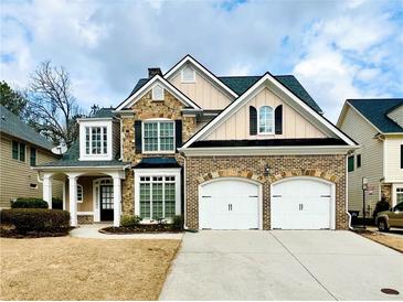 Charming brick and stone two-story home featuring a two-car garage and well-manicured lawn at 576 Lawton Bridge Sw Rd, Smyrna, GA 30082