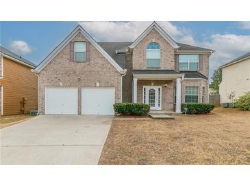 Charming two-story brick home with a two-car garage and well-maintained front yard at 610 Maltese Dr, Atlanta, GA 30349