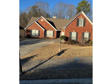 Charming red brick home with a well-manicured lawn and a concrete driveway, and a two car garage at 1176 Whatley Mill Ln, Lawrenceville, GA 30045