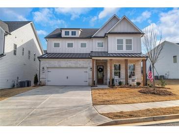 Charming two-story home with a brick and siding exterior, two-car garage, and covered front porch at 335 Tillman Pass, Woodstock, GA 30188