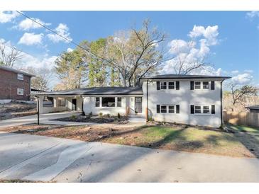 Charming two-story home with a manicured lawn and inviting entryway, painted white with black shutters at 3187 Clifton Church Rd, Atlanta, GA 30316