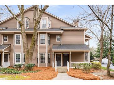 Two-story townhome with neutral siding and a cozy covered entrance, surrounded by mature trees and landscaping at 2116 N Forest Trl, Atlanta, GA 30338