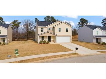 Charming two-story home featuring a well-manicured front yard and a two-car garage at 310 Indian Lake Trl, Villa Rica, GA 30180