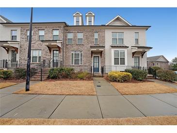 Charming townhome exterior with brick facade, dormer windows, and well-maintained landscaping at 2051 Glenview Park Cir, Duluth, GA 30097