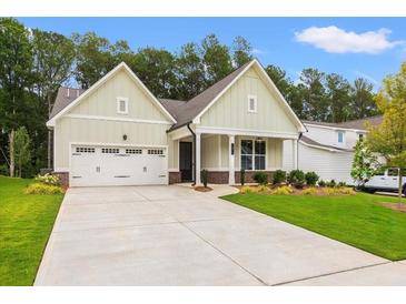 Charming craftsman home with a two-car garage, manicured lawn and beautiful landscaping at 1019 Cooks Farm Way, Woodstock, GA 30189