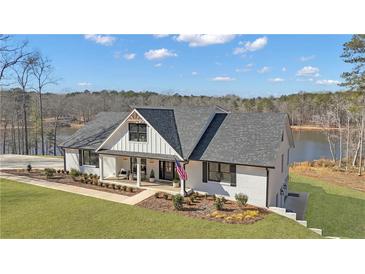 Stunning exterior of a lakefront home featuring a well-manicured lawn, stylish design and a serene lakeside setting at 459 Lester Rd, Fayetteville, GA 30215