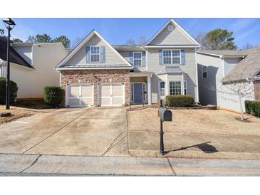 Charming two-story home features a stone-accented facade, a two car garage and well-manicured landscaping at 102 Crescent Woode Way, Dallas, GA 30157