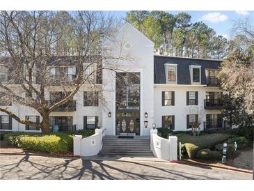 Beautiful condo building with white facade, black shutters, and manicured landscaping, offering a stylish and inviting entrance at 3110 Pine Heights Ne Dr, Atlanta, GA 30324