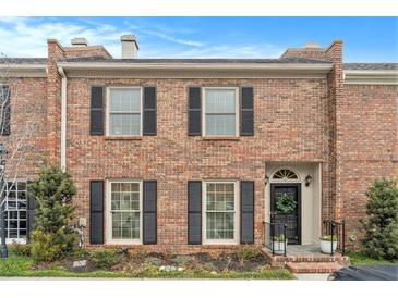 Charming brick townhome with black shutters, a black door, and manicured landscaping at 8 Kings Ne Walk, Atlanta, GA 30307