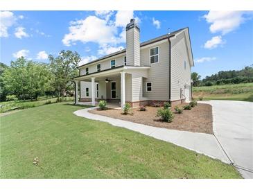 A charming two-story home features a covered porch, manicured lawn, and a private driveway at 878 Forrester Cemetery Rd, Covington, GA 30014