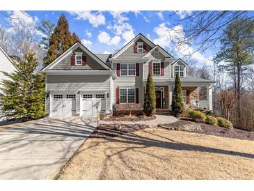 Charming two-story home featuring a manicured lawn, two-car garage and beautifully landscaped front yard at 423 Treetop Cir, Canton, GA 30115