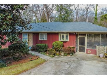 Cozy single-story home featuring a screened porch, mature landscaping, and a concrete driveway at 42 W Belle Isle Ne Rd, Atlanta, GA 30342