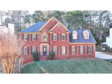 Two-story brick home with a blue roof, dormer windows, and manicured front lawn at 420 Woodbrook Way, Lawrenceville, GA 30043