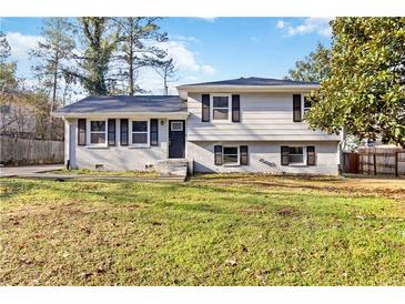 Charming split-level home with freshly painted white brick and dark shutters on a sunny day at 8331 Attica Ct, Jonesboro, GA 30238
